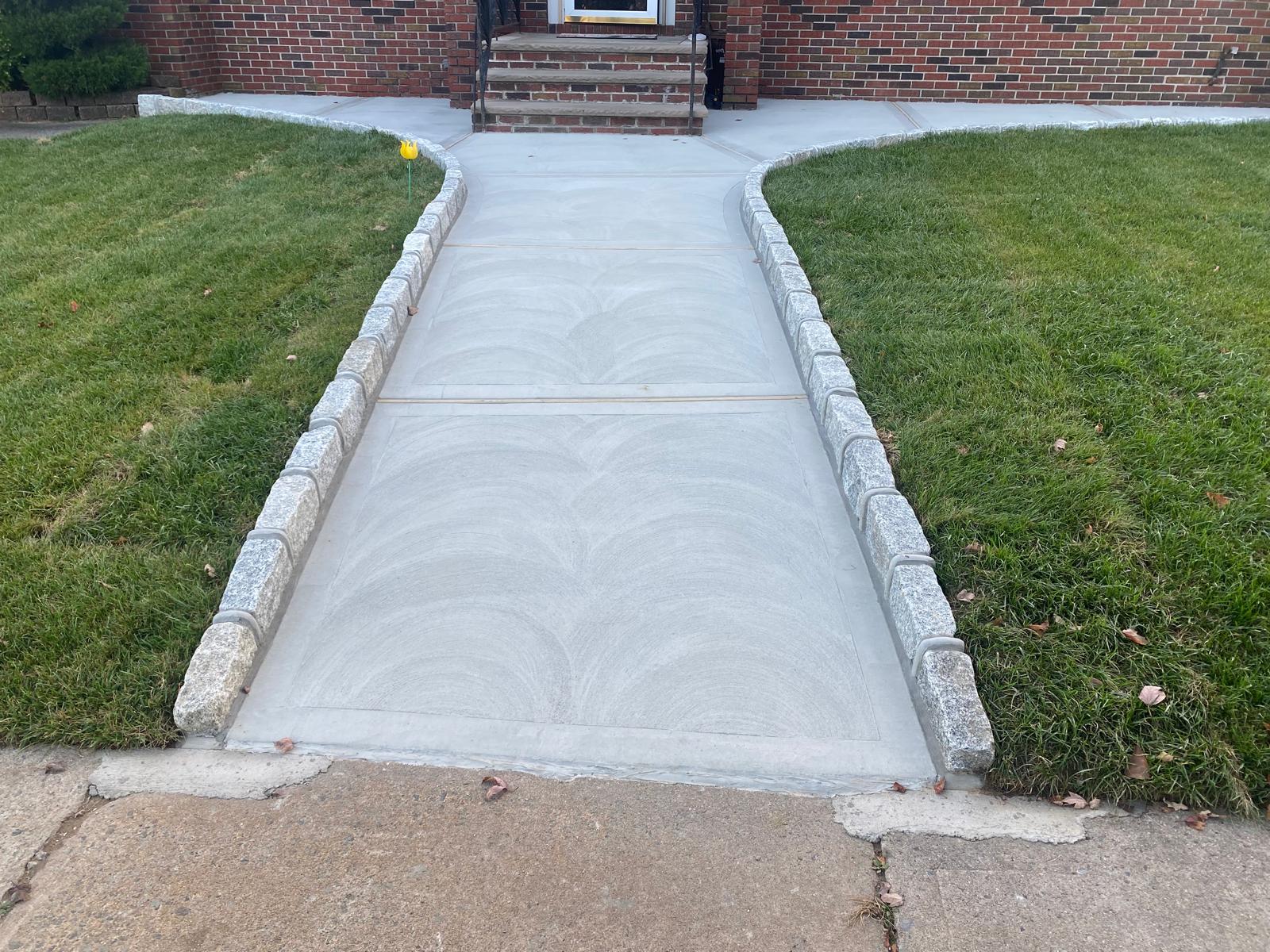 New concrete sidewalk replacement in front of a house